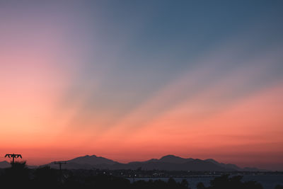 Scenic view of silhouette mountains against romantic sky at sunset