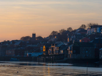 Houses in town against sky during sunset