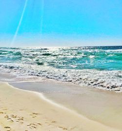 Scenic view of beach against clear blue sky