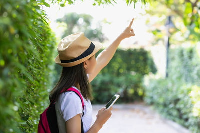 Rear view of woman gesturing while using mobile phone