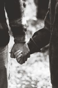 Midsection of couple holding hands