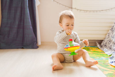 Cute boy looking down while sitting on floor