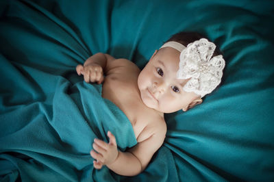 Portrait of cute baby lying on bed