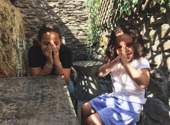 Portrait of girl with mother sitting at outdoors cafe