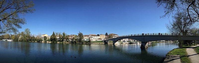 Bridge over river against clear blue sky