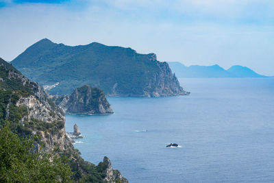 High angle view of sea by mountains against sky