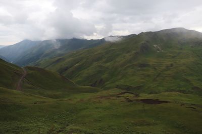 Scenic view of mountains against cloudy sky