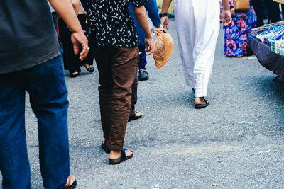 Low section of people walking on road