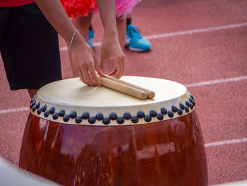 Midsection of person holding drumsticks