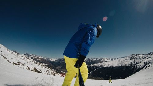 Man standing on snow covered mountain against sky