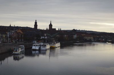 Boats in river with city in background