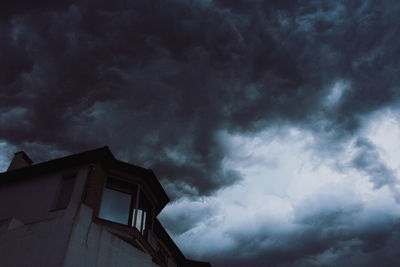 Low angle view of building against cloudy sky