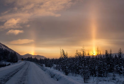 Snow covered road against sky during halo