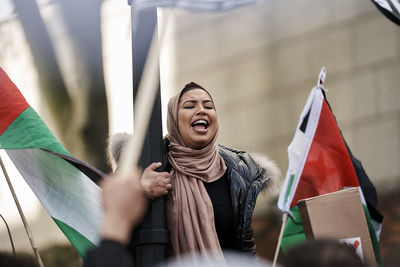 Low angle view of woman holding flag