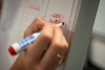 Close-up of hand writing on paper