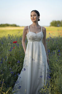 Portrait of young woman standing on field