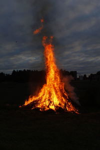 Campfire on field against sky at sunset