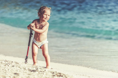 Full length of shirtless boy on beach