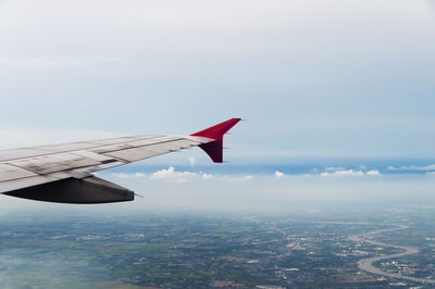 Cropped image of airplane flying over clouds