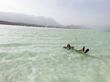 High angle view of person swimming in lake against clear sky