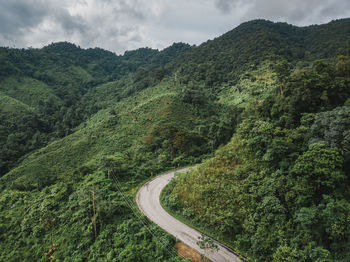 Road amidst green landscape against sky