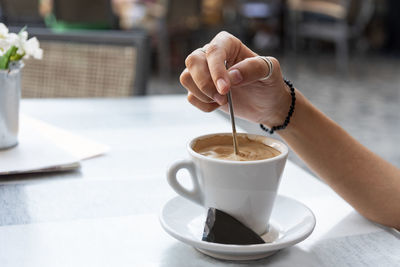 Woman holding coffee cup on table