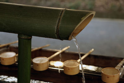Close-up of water falling from bamboo dipper at shrine