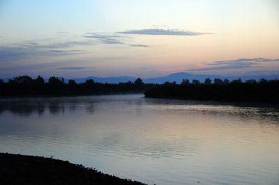 Scenic view of lake against sky at sunset