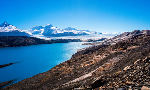 Scenic view of snowcapped mountains against blue sky