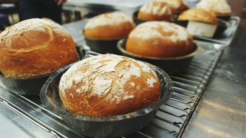 Close-up of fresh breads in bowls on metal grate