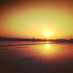 Scenic view of lake against orange sky