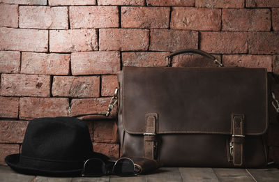 Close-up of leather bag on old brick wall