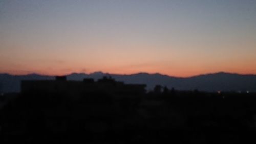 Silhouette landscape against clear sky during sunset