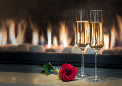 Champagne flutes with red rose on table