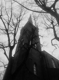 Low angle view of trees and building against sky