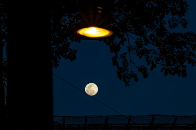 Low angle view of illuminated moon against sky at night