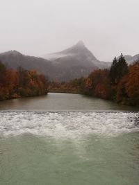 Scenic view of lake by mountains against sky