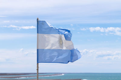 Flag in sea against sky