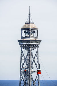 Lookout tower by sea against clear sky