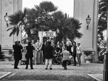 People standing by palm tree in city