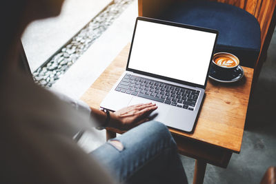 Midsection of woman using laptop at home