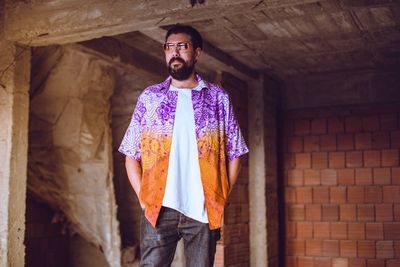 Mid adult man wearing sunglasses standing against brick wall