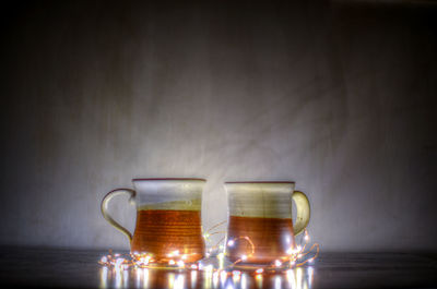 Close-up of wine glass on table against wall