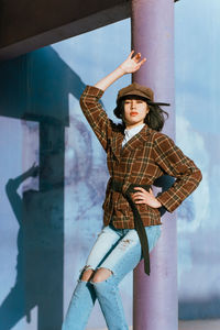 Portrait of woman standing against wall