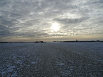 Scenic view of frozen lake against sky during sunset