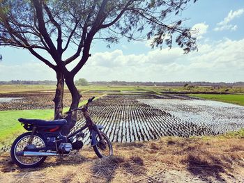 Bicycle parked on field against sky