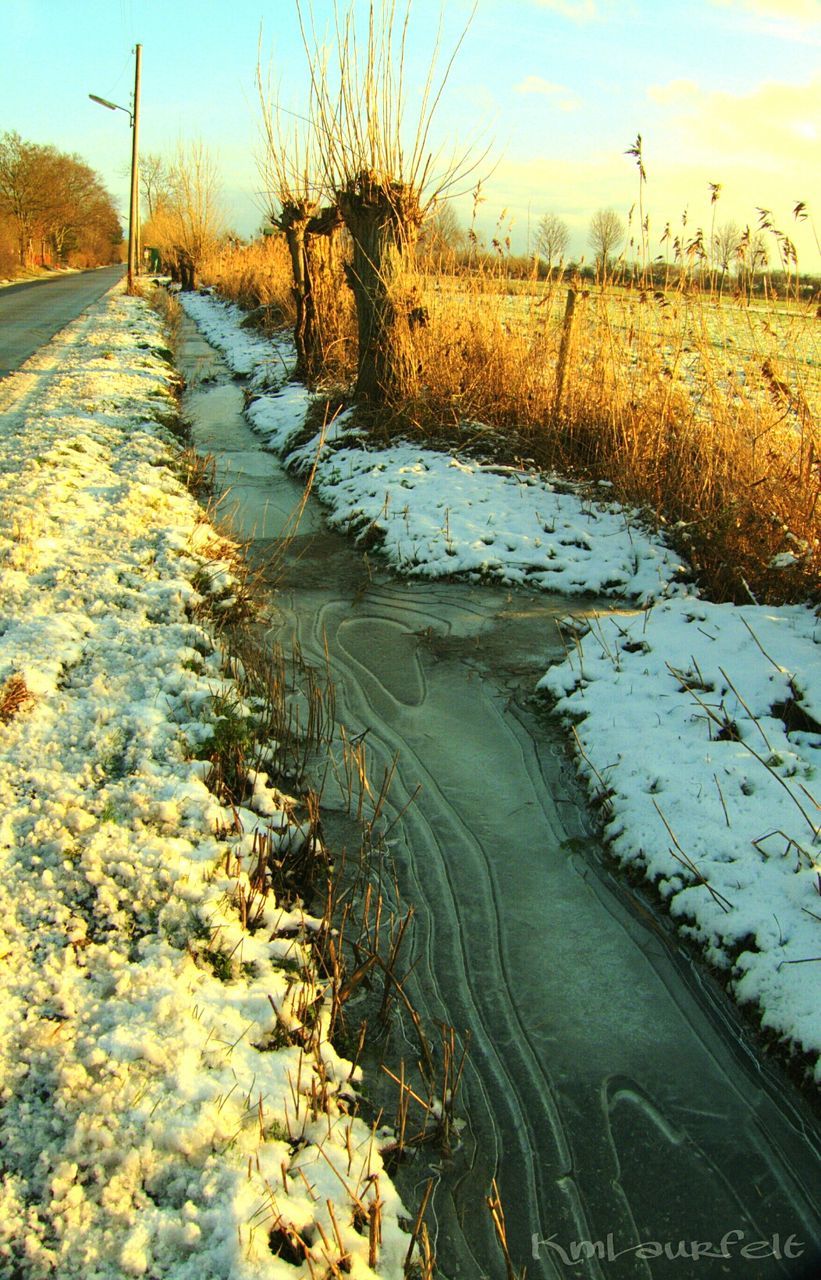 water, reflection, tranquility, tranquil scene, nature, river, scenics, beauty in nature, stream, the way forward, diminishing perspective, lake, sky, surface level, grass, wet, tree, no people, road, outdoors