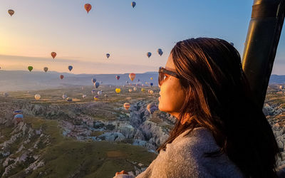 Close-up of woman with balloons against sky