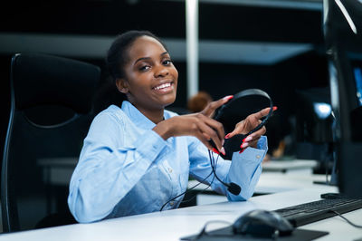 Portrait of smiling businesswoman using mobile phone in office