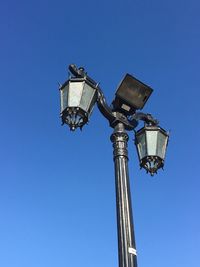 Low angle view of communications tower against blue sky